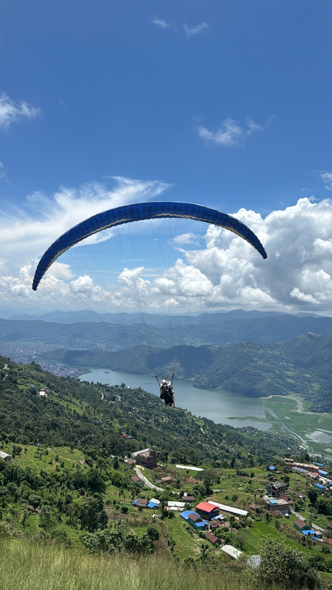 Blue paraglider above Pokhara hills